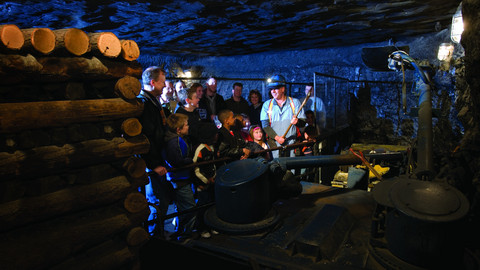A facilitator demonstrates an old machine in the Coal Mine.