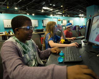 A summer camp participant uses a computer in the Fab Lab.