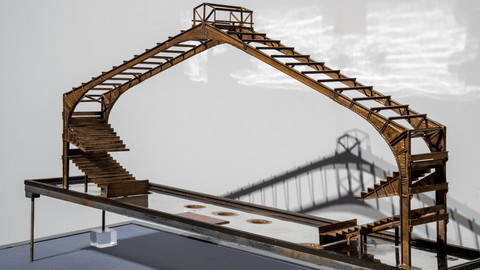Section of a metal model of the International Ampitheater with arched roof and seating tiers.