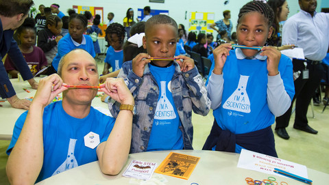 Two young participants and a Griffin MSI employee play their homemade kazoos.