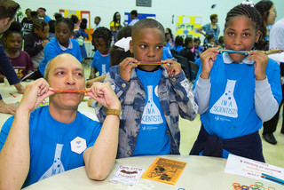 Two young participants and a Griffin MSI employee play their homemade kazoos.