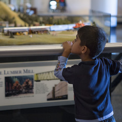 Child observing The Great Train Story over a railing.